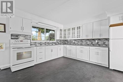 Kitchen showing both fridge & stove & as well as lovely back splash + big window overlooking rear yard - 815 Joseph Street E, Cardinal, ON - Indoor Photo Showing Kitchen