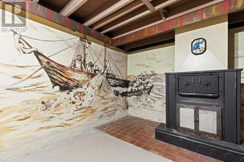 Recreation room with old fashioned wood stove, as/is & the most ornate of the murals, done in 3d.  Gorgeous.  Check out what the fisherman caught in the net! - 815 Joseph Street E, Cardinal, ON - Indoor Photo Showing Basement