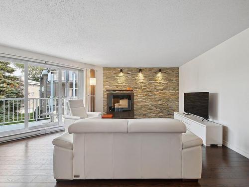 Living room - 201-718 Place De Monaco, Laval (Chomedey), QC - Indoor Photo Showing Living Room With Fireplace