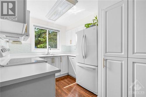 The custom kitchen has been completely redone. The double doors conceal the full size washer/dryer. - 260 Brittany Drive Unit#103, Ottawa, ON - Indoor Photo Showing Kitchen