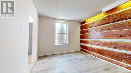 The log feature wall in the Living Rm is not a veneer or decorator's touch.  Its the real thing & it points to the circa 1900 original construction date (as per Geo) - 21 Elgin Street E, Arnprior, ON - Indoor Photo Showing Other Room