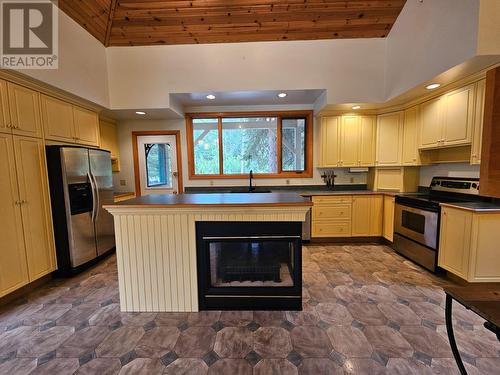 4850 East Arras Road, Dawson Creek, BC - Indoor Photo Showing Kitchen With Fireplace