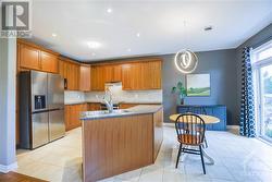 Adjacent is the open-concept family room, seamlessly connecting to the lovely kitchen equipped with stainless steel appliances, extra tall cabinets,  counter space, and a center island. - 