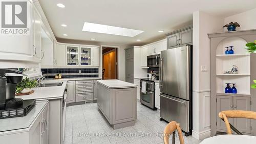 Corian Countertops, Stainless steel appliances - 21709 Wonderland Road N, Middlesex Centre, ON - Indoor Photo Showing Kitchen With Double Sink