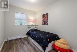 Bedroom with baseboard heating and hardwood / wood-style flooring - 