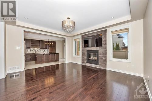 Living Room with fireplace looking into Kitchen - 231 Des Soldats-Riendeau Street, Ottawa, ON - Indoor With Fireplace