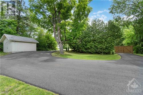 New paved driveway (2023) with a gate and the large shed at the front of the home. - 698 Moffat Street, Pembroke, ON - Outdoor