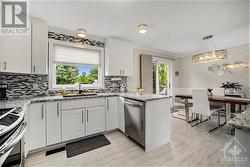 Open concept kitchen and dining area with access to back deck via patio door - 