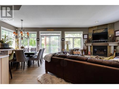 Comfy ""great"" room as part of the open kitchen/dining area - 1831 Horizon Drive, West Kelowna, BC - Indoor With Fireplace