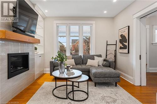 The mantle is a striking, natural centerpiece crafted from rich douglas fir, showcasing warm wood tones and distinctive grain patterns that bring character and elegance to any space. - 1371 3Rd Avenue E, Owen Sound, ON - Indoor Photo Showing Living Room With Fireplace