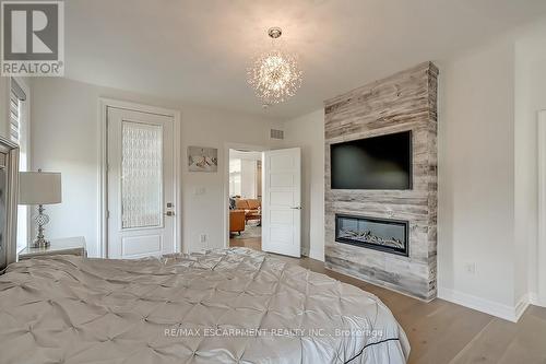 23 Whitcombe Way, Puslinch, ON - Indoor Photo Showing Bedroom With Fireplace