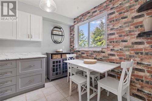 Eating area with faux brick accent wall - 323 Main Street W Unit#302, Merrickville, ON - Indoor Photo Showing Dining Room