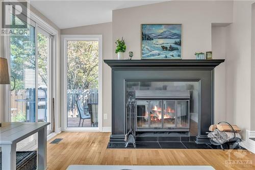 Sunken family room w/ wood-burning fireplace. - 1719 Des Broussailles Terrace, Ottawa, ON - Indoor Photo Showing Living Room With Fireplace