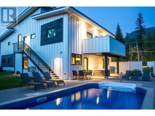 Pool Area at Dusk - 2043 Airport Way, Revelstoke, BC - Outdoor With In Ground Pool With Deck Patio Veranda