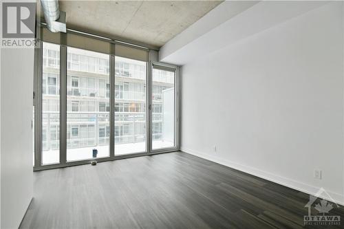 LIVING SPACE | hardwood flooring & 9' ceilings throughout, door to balcony - 354 Gladstone Avenue Unit#502, Ottawa, ON - Indoor Photo Showing Other Room