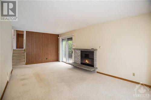 Living room features electric insert fireplace with sliding doors to deck - 1056 Harkness Avenue, Ottawa, ON - Indoor With Fireplace