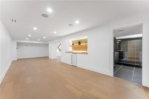 Lower level Family Room. Wet bar, bar fridge, ambient lighting on oak shelving. Spacious 3 piece bathroom. - 5427 Anthony Place, Burlington, ON - Indoor Photo Showing Other Room