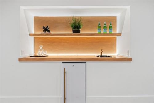 Lower level wet bar area. Oak shelving & counter, sink, bar fridge, ambient lighting - 5427 Anthony Place, Burlington, ON - Indoor Photo Showing Other Room