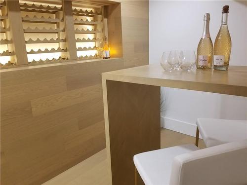 Wine Bar. Backlit wine rack, built-in table, white oak wall and flooring. - 5427 Anthony Place, Burlington, ON - Indoor