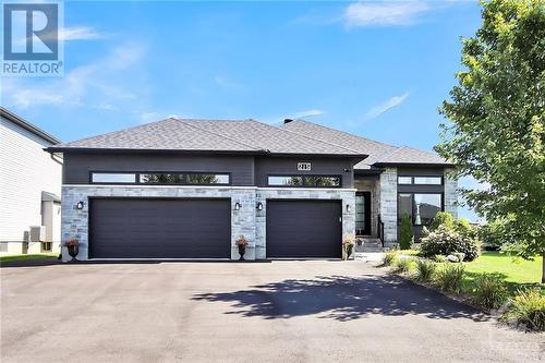 One of the stand-out features is the insulated triple car garage, ideal for any project enthusiast. Plus, the extended driveway accommodates up to 6 more vehicles, making it perfect for gatherings. - 215 Capri Avenue, Embrun, ON - Outdoor With Facade