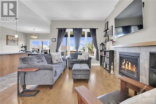 The sun-filled living room hosts a cozy gas fireplace, setting the stage for family moments. - 215 Capri Avenue, Embrun, ON - Indoor Photo Showing Living Room With Fireplace