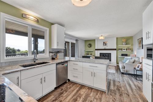 1715 Sonora Drive, Kelowna, BC - Indoor Photo Showing Kitchen With Fireplace With Double Sink