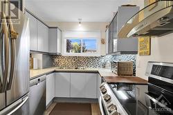 Kitchen with Corian countertop and stainless steel appliances...note decor backsplash. - 