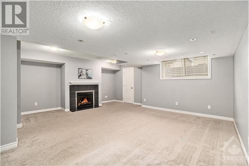 Large finished basement with a cozy fireplace—perfect for relaxation and entertaining. - 445 Barrick Hill Road, Ottawa, ON - Indoor With Fireplace