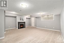 Large finished basement with a cozy fireplace—perfect for relaxation and entertaining. - 