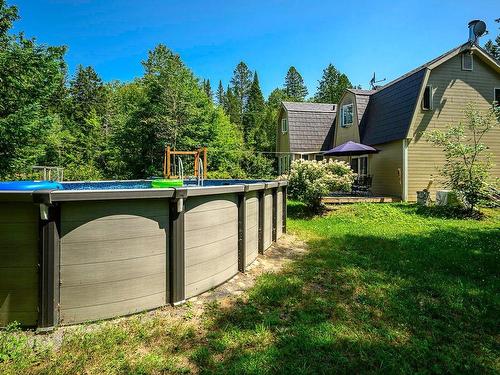 Backyard - 15 Rue Du Domaine-Després, Sainte-Marguerite-Du-Lac-Masson, QC - Outdoor With Above Ground Pool