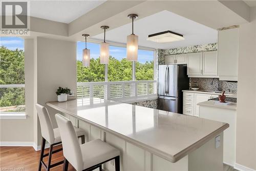 Breakfast bar with quartz countertops & SS appliances. - 3 Towering Heights Boulevard Unit# 303, St. Catharines, ON - Indoor