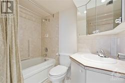 Main Bathroom with full tub tiling and decor mirrors. - 