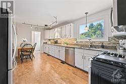 Chef's kitchen with granite countertop, plenty of cupboard space, gas stove and comfortable cork flooring - 