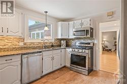 Chef's kitchen with granite countertop, plenty of cupboard space, gas stove and comfortable cork flooring - 