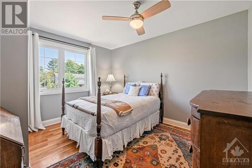 Bedroom 1: 12'2" x 10'7", featuring cherry hardwood flooring and ceiling fan - 10 Riverbrook Road, Ottawa, ON - Indoor Photo Showing Bedroom