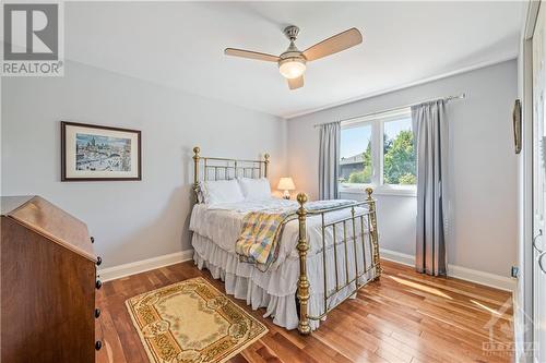 Bedroom 1: 12'9" x 10'8", featuring cherry hardwood flooring and ceiling fan - 10 Riverbrook Road, Ottawa, ON - Indoor Photo Showing Bedroom