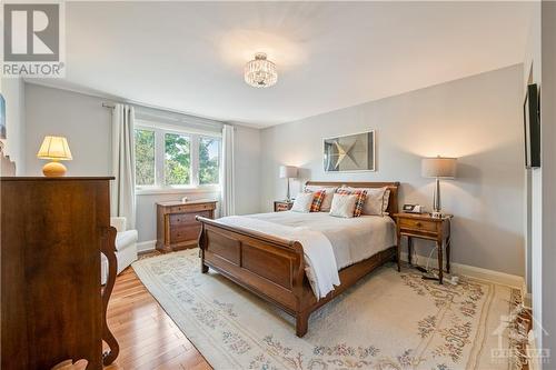 Primary Bedroom: 16'7" x 12'10" featuring cherry hardwood flooring, walk-in closet and ensuite - 10 Riverbrook Road, Ottawa, ON - Indoor Photo Showing Bedroom