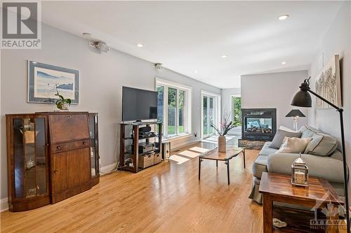 37'4" x 19' Family Room featuring oak hardwood flooring and a 3-Way Gas Fireplace with Remote - 10 Riverbrook Road, Ottawa, ON - Indoor With Fireplace