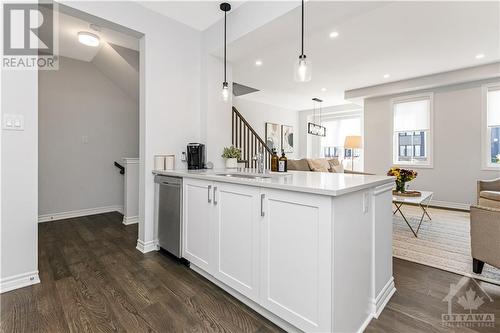 A convenient eat up island adds extra seating and prep space, while a built-in pantry provides additional storage. - 97 Ballinora Lane, Ottawa, ON - Indoor Photo Showing Kitchen