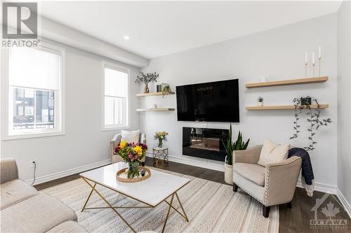 The seamless flow from room to room ensures that you can enjoy quality time with loved ones while soaking in the abundant natural light from the oversized windows throughout. - 97 Ballinora Lane, Ottawa, ON - Indoor Photo Showing Living Room With Fireplace