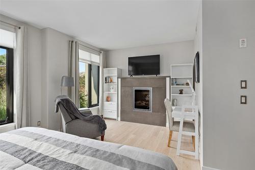 111-600 Sarsons Road, Kelowna, BC - Indoor Photo Showing Bedroom With Fireplace