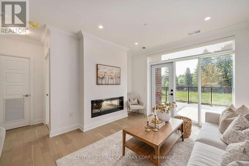 Living room opens to terrace with garden view - 109 - 1560 Upper West Avenue, London, ON - Indoor Photo Showing Living Room With Fireplace