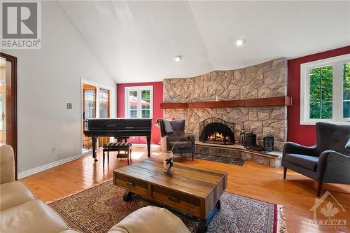 As you enter, you'll appreciate the spacious layout that separates the principal living areas from the private bedrooms - 1390 Millburn Crescent, Ottawa, ON - Indoor Photo Showing Living Room With Fireplace