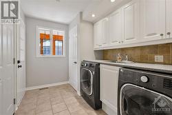 Main floor laundry room with direct access to the garage, solarium, and basement - 