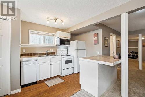 Lower ktichen complete with dishwasher and microwave hood fan - 111 Erin Meadow Green Se, Calgary, AB 