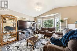 Spacious main floor living room with vaulted ceilings and bay window - 