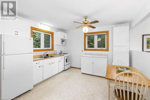 The current kitchen is crisp, and clean, but offers endless options for an eventual redesign. - 139 Ivy Drive, Georgian Bluffs, ON - Indoor Photo Showing Kitchen With Double Sink