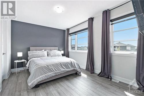 The large second bedroom is perfect for family members or guests.  Two large windows fill the room with natural light, creating a bright and welcoming atmosphere. The clean lines echo the seamless - 708 Geneva Crescent, Embrun, ON - Indoor Photo Showing Bedroom