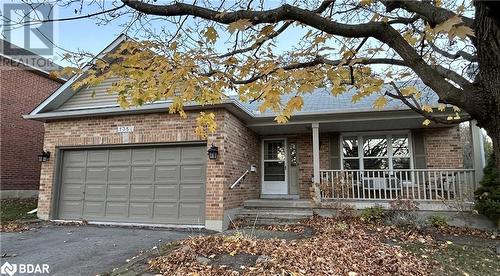 View of front of home with a garage and covered porch - 1358 Bobolink Court, Peterborough, ON - Outdoor With Deck Patio Veranda