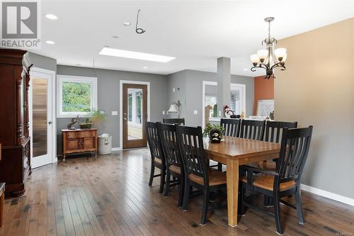 Dining space featuring a notable chandelier, a skylight, and dark hardwood / wood-style flooring - 773 Terrien Way, Parksville, BC - Indoor Photo Showing Dining Room